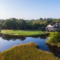 Golf course green by water and clubhouse